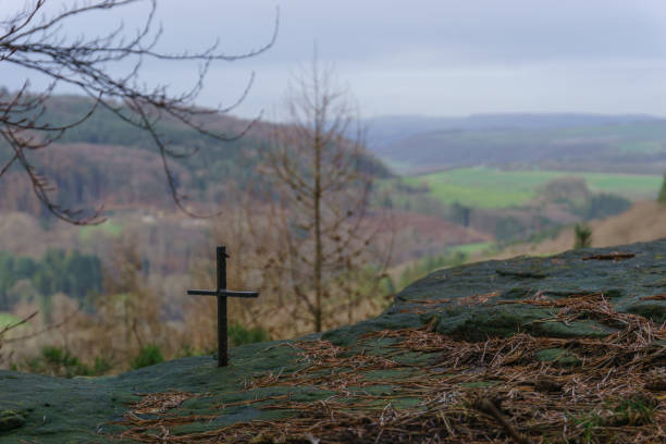 istock small iron cross on rock formation with blurry landscape in background 1314922459