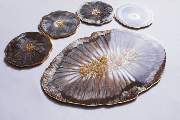 Cup holder, epoxy resin tray, marine-style stone cut on grey background. Brown and grey stains of paint, gold trim. Subject for table setting.  Gloss, reflection. Epoxy resin coaster. Home decor