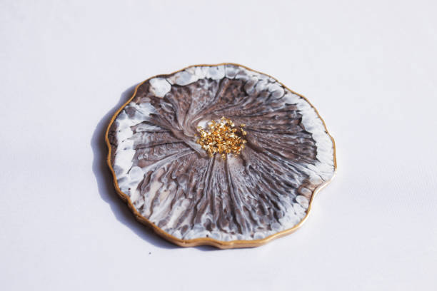 istock Cup holder, epoxy resin tray, marine-style stone cut on grey background. Brown and grey stains of paint, gold trim. Subject for table setting.  Gloss, reflection. Epoxy resin coaster. Home decor 1314923185