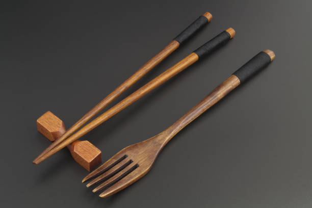 istock Wooden chopsticks and fork on black table 1314923658