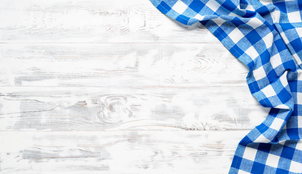 White wooden table covered with blue tablecloth.