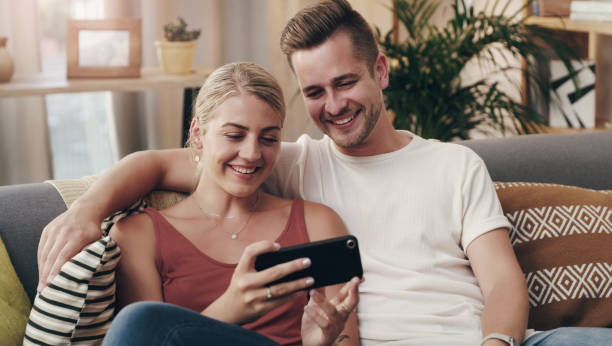 istock Shot of a young couple using a smartphone on the sofa 1314926441