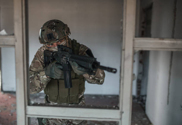 istock Confident soldier in camouflage uniform aiming with rifle in battle 1314926673