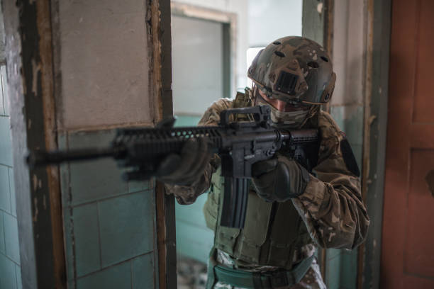 istock Soldier in camouflage uniform aiming with rifle in war zone 1314927075