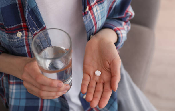 Young woman with abortion pill and glass of water indoors, closeup Young woman with abortion pill and glass of water indoors, closeup birth control pill stock pictures, royalty-free photos & images