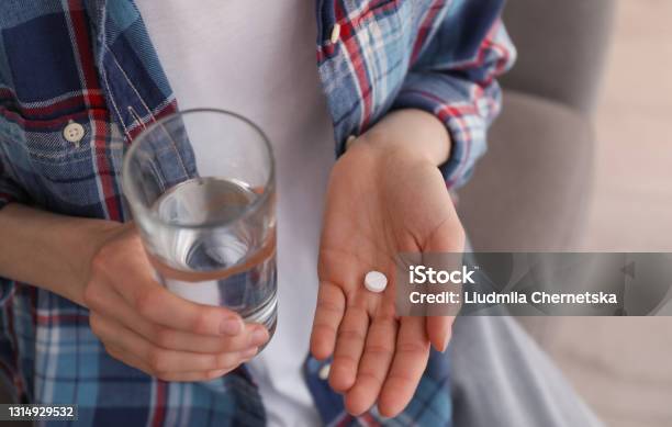 Young Woman With Abortion Pill And Glass Of Water Indoors Closeup Stock Photo - Download Image Now