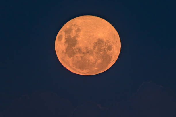istock Pink supermoon and full moon with faint cloud bank below 1314930834