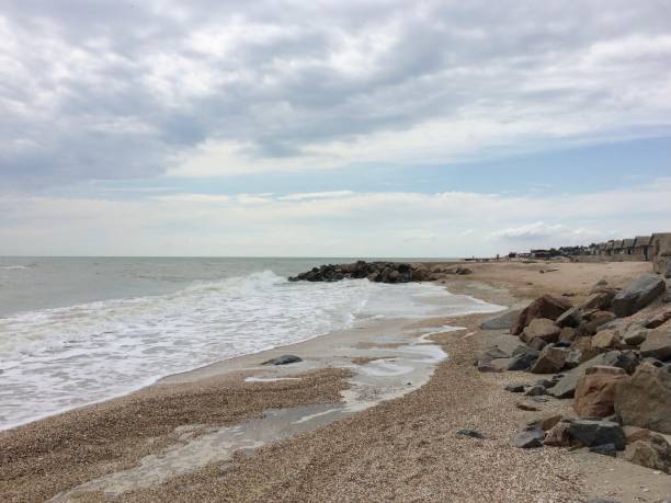 istock Autumn sea coast landscape. Sandy beach with medium size sharp rocks down the the seaside 1314933588
