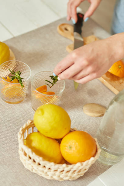 istock Female hand put rosemary in glasses, making fresh lemonade 1314934715