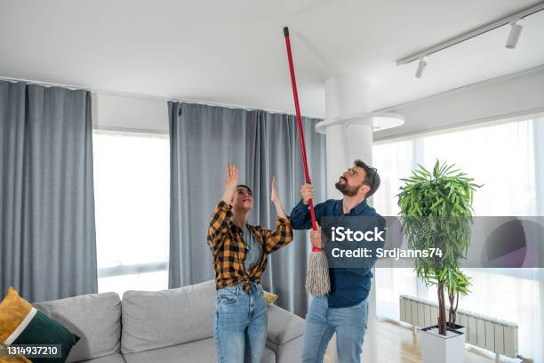 A Young Couple Stares At The Ceiling And Yells Because A Neighbor Upstairs Is Having A Party With Loud Music Or Renovating An Apartment And Workers Are Drilling With Heavy Tools Stock Photo - Download Image Now