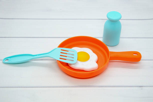 istock Still life of toy plastic dishes: frying pan with lid, fried eggs, salt shaker, spatula. Evolving role-playing games 1314937604