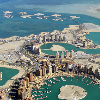 Aerial view of the Pearl Qatar on a sunny day in Doha, Qatar. An artificial island spanning nearly four square kilometers. The Pearl Qatar will create over 32 kilometers of new coastline, for use as a residential estate. It is the first land in Qatar to be available for freehold ownership by foreign nationals.