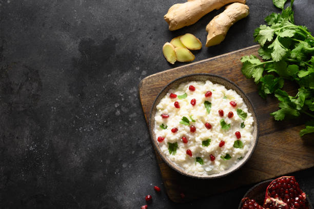 istock Curd Rice with pomegranate, cilantro, mustard seeds, ginger on a black background. Indian cuisine 1314941196