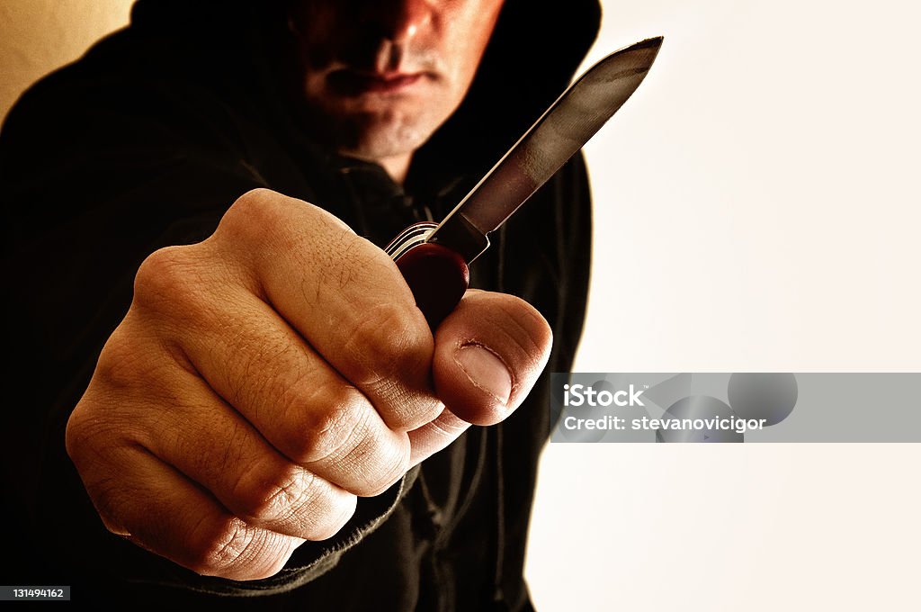Robbery Crouching robber with small knife Adult Stock Photo