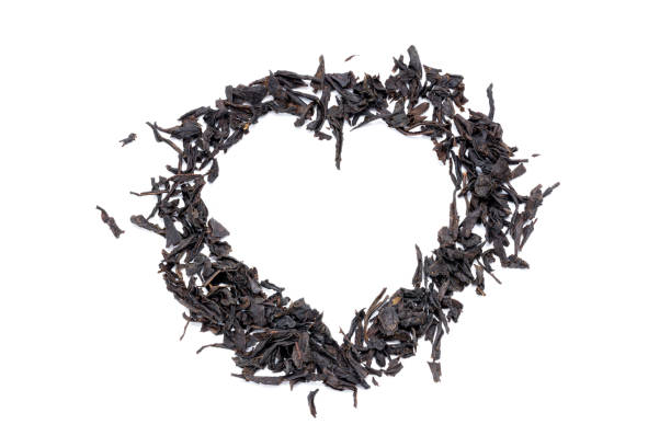 pilha de chá preto seco isolado em fundo branco. folha de chá seca indiana cortada. forma do coração - heart shape isolated isolated on white tea leaves - fotografias e filmes do acervo