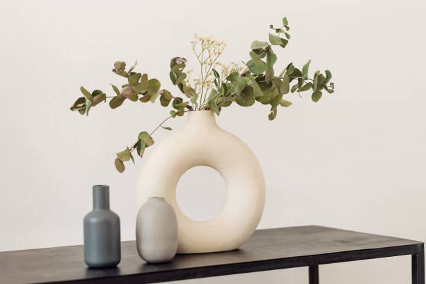 vaso elegante creativo bianco con rami di eucalipto e gypsophila su una mensola nera. interior design. stile minimalista. - shelf wall vase indoors foto e immagini stock