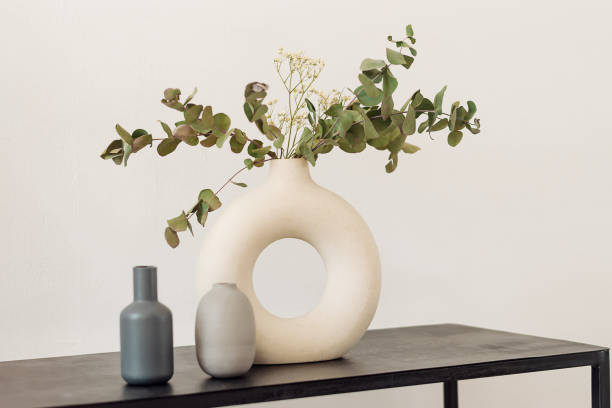 istock White creative stylish vase with eucalyptus branches and gypsophila on a black shelf.Interior design.Minimalistic style. 1314945382