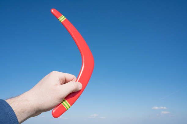 Boomerang in hand, run on blue sky background. Business concept.