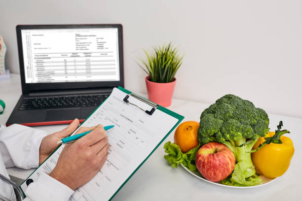 clinical nutritionist or dietitian builds a personalized meal plan for a patient which includes vegetables and fruits. healthy diet - eating female healthcare and medicine healthy lifestyle imagens e fotografias de stock