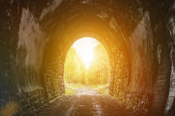 uscire dal tunnel al bagliore del sole. - luce alla fine del tunnel foto e immagini stock