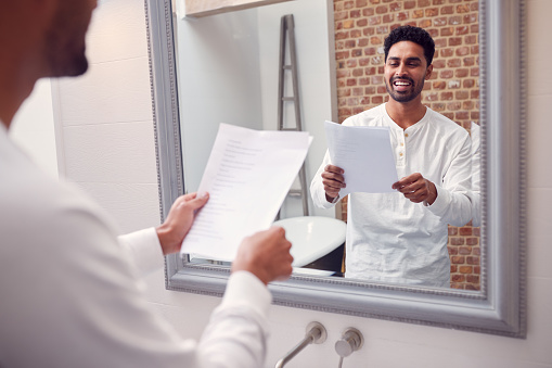 Man At Home Practising Giving Speech Or Presentation In Bathroom Mirror