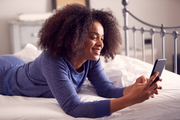 istock Woman Lying On Bed With Mobile Phone Wearing Pyjamas 1314945904