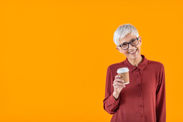 istock Cheerful Mature woman holding a cup of coffee while looking at camera 1314949285