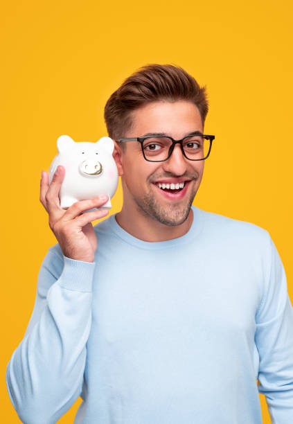 istock Cheerful guy checking piggy bank 1314949392