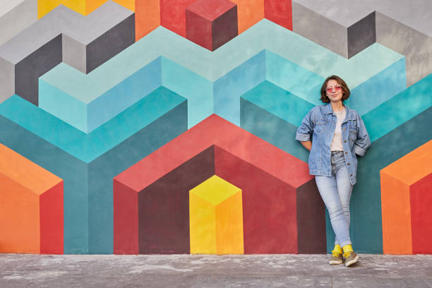 istock Happy woman leaning on colorful wall 1314949469