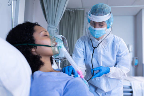 istock Caucasian doctor in ppe suit examining with stethoscope female patient with oxygen ventilator 1314949509