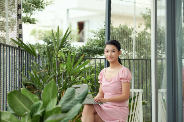 istock happy confident woman using laptop while sitting on balcony and working from home. 1314949629