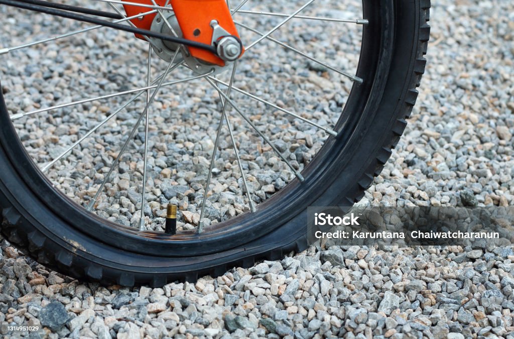 Close up of flat tire bicycle on dirt road with selective focus. Bicycle Stock Photo