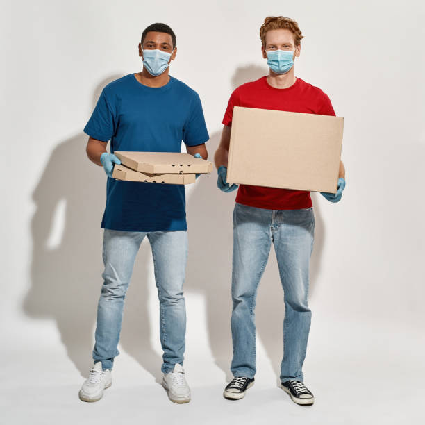 istock Multiracial postmen in gloves and masks holding boxes 1314952089