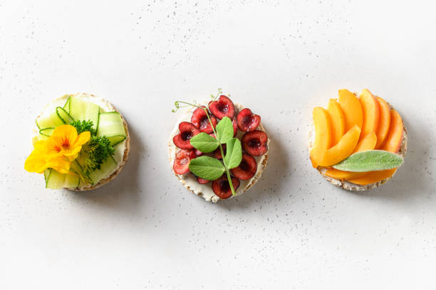 Puffed rice cakes with different toppings berries and vegetables on white. Vegan snacks.