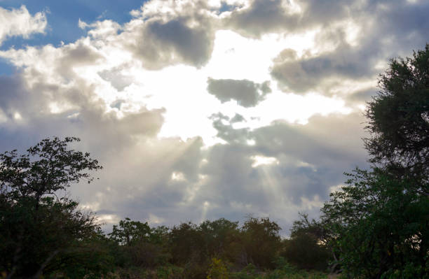 Sunbeams break through the moody clouds with the sun rising