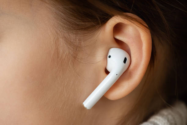 wireless earphone in the girl's ear. - young ears imagens e fotografias de stock