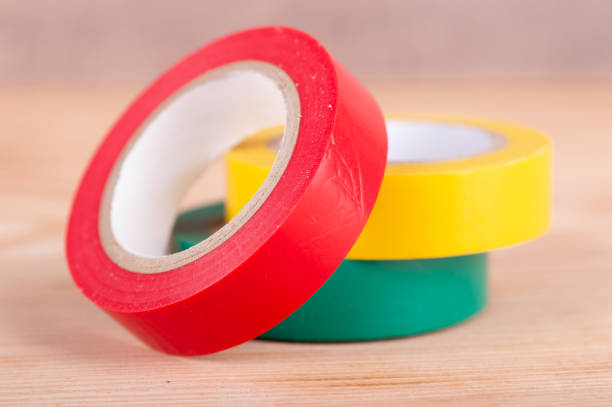 Multicolored insulating tapes rolls on wooden background close upMulticolored insulating tapes rolls