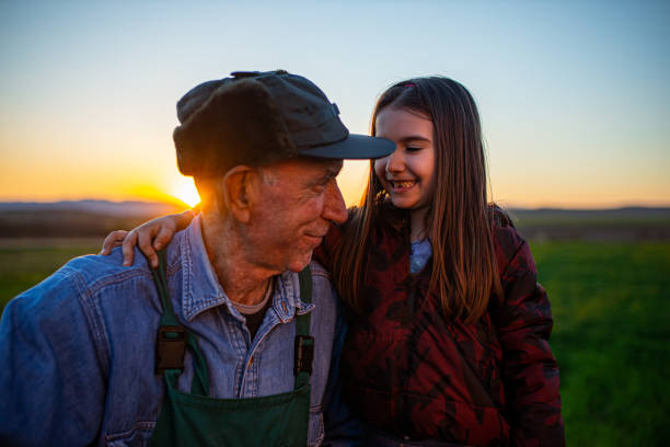 фермер и улыбающаяся маленькая девочка - grandparent grandfather granddaughter little girls стоковые фото и изображения