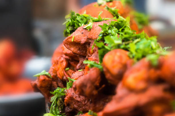 Spicy roasted chicken or tandoori chicken garnished with mint leaves . Indian non vegetarian street food. background.