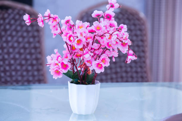istock Pink artificial flowers in a vase on a  white table for decoration , background 1314957527