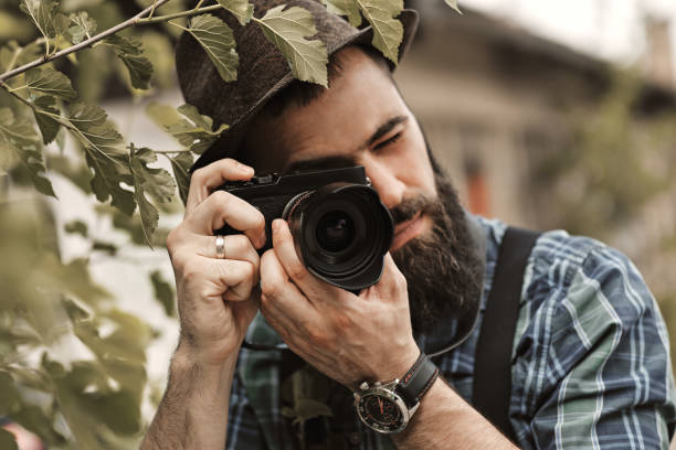 istock A handsome young man with a beard is taking photos in a green park. 1314958838