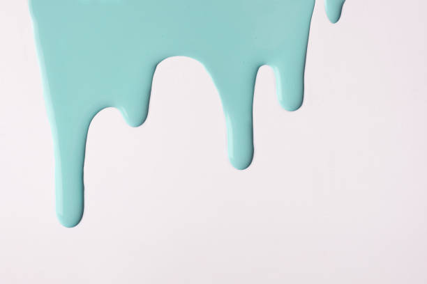 istock Light cyan liquid drops of paint color flow down on isolated white background. Abstract turquoise backdrop. 1314959070