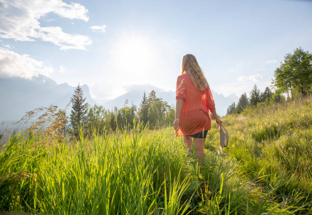 Mature woman walks along mountain ridge in the morning In deep grasses, with hat older women short skirts stock pictures, royalty-free photos & images