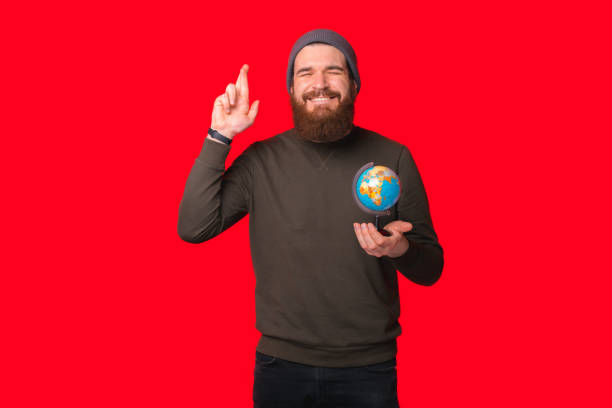 istock Bearded man is making a wish to travel while holding a earth globe. 1314960494