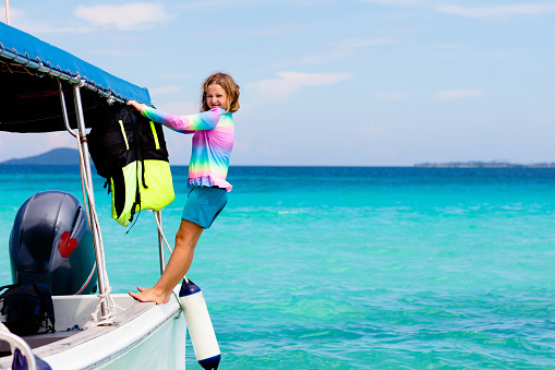 Kids jump into sea. Yacht vacation with child on exotic tropical island with crystal clear water. Beach and swim fun. Sailing and cruise with children. Summer holiday on boat. Little boy swimming.