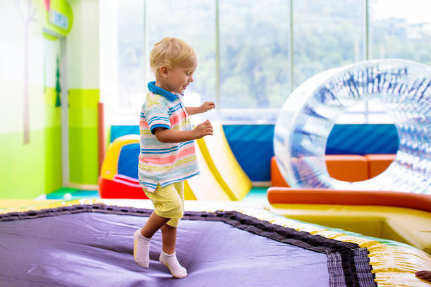 istock Child jumping on colorful playground trampoline 1314961199