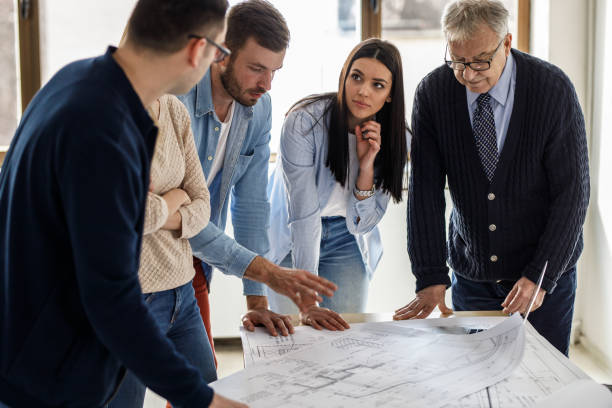 istock College professor examining blueprint with group of his students 1314962529
