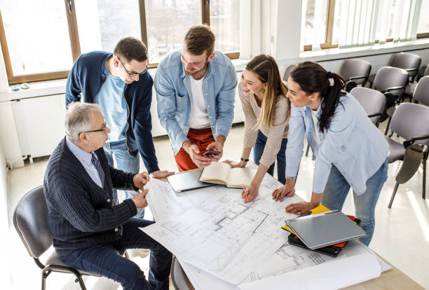istock College professor examining blueprint with group of his students 1314963044