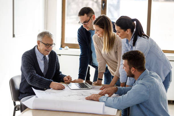 istock College professor examining blueprint with group of his students 1314963084