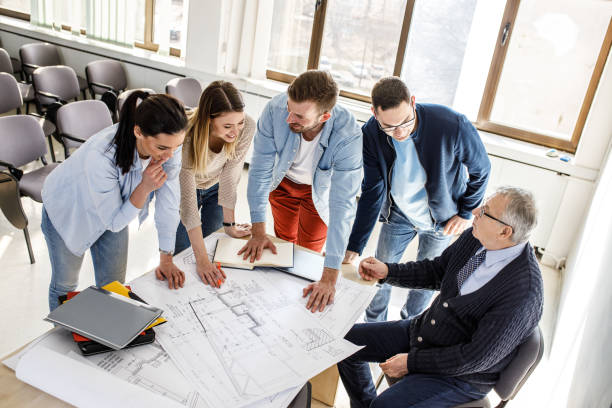 istock College professor examining blueprint with group of his students 1314963097